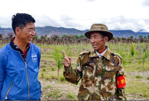 西藏南木林县艾玛乡德庆村63岁的赤列与村主任潘多在交流护林经验.