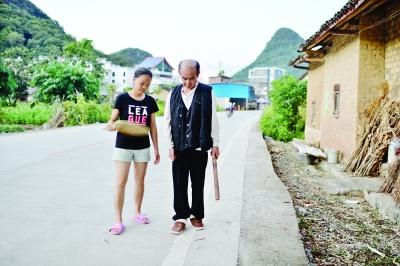 陈春林陪着父亲陈世日在村子里散步锻炼 记者胡冬冬 摄