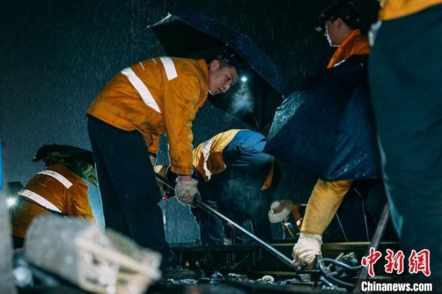 图为重庆工务段人员在拆除钢轨扣件。　蒋凌峰 摄